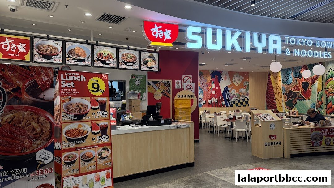 The Sukiya Tokyo Bowls & Noodles shop front with a prominent sign and displayed food items.