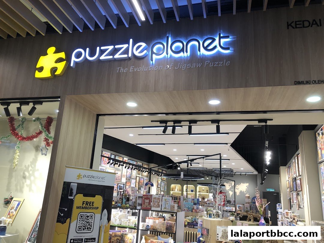 The entrance of Puzzle Planet, a shop selling jigsaw puzzles, with its neon sign and display of puzzles.