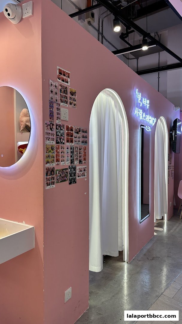 Pink photo booth area with curtains, mirrors, and photo displays.