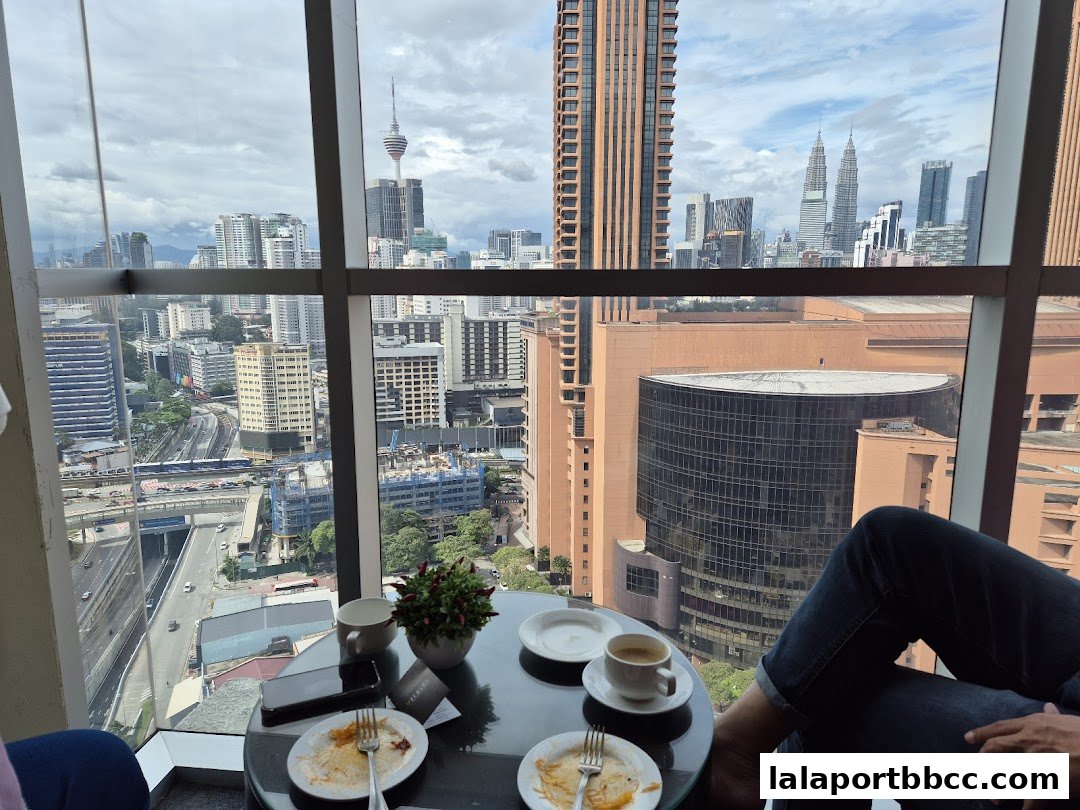 A table with coffee cups and plates overlooking a city skyline.