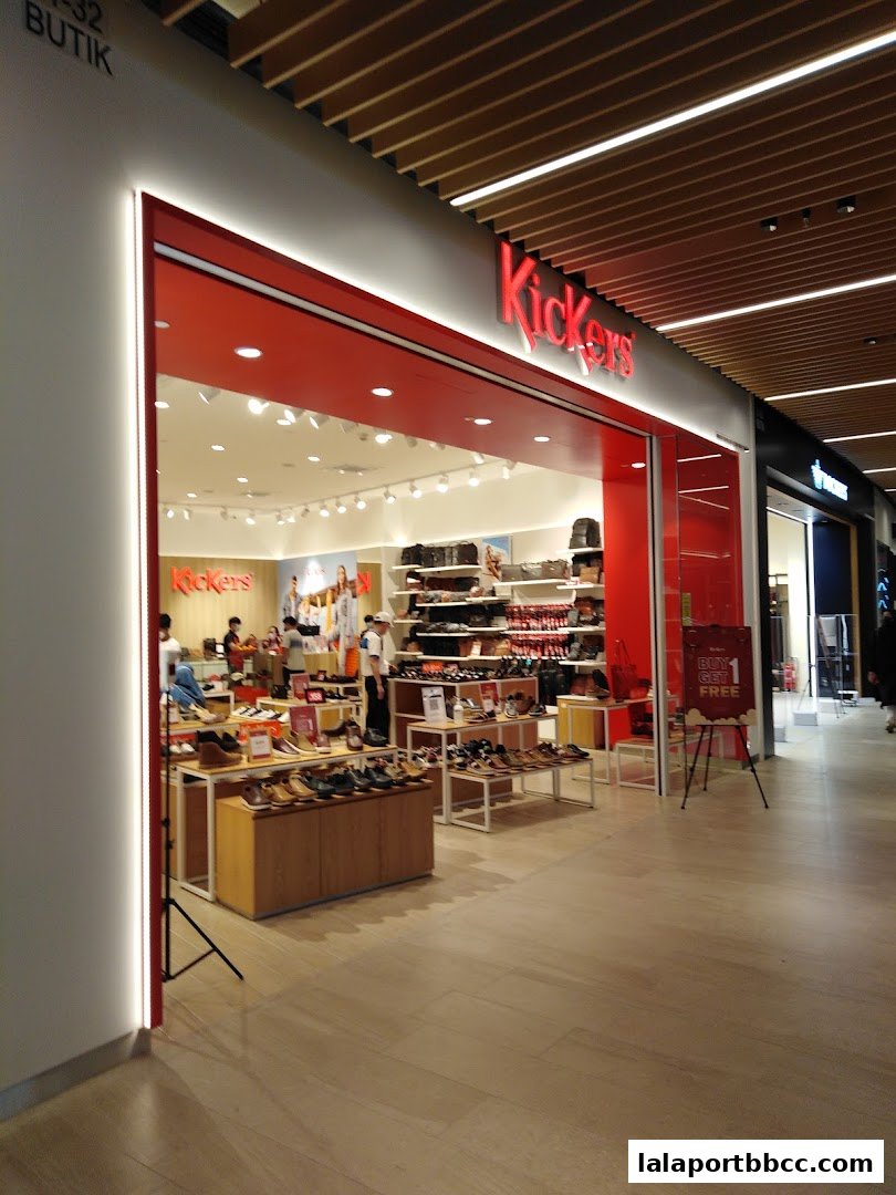 The entrance of a Kickers shoe store displaying various footwear and bags.