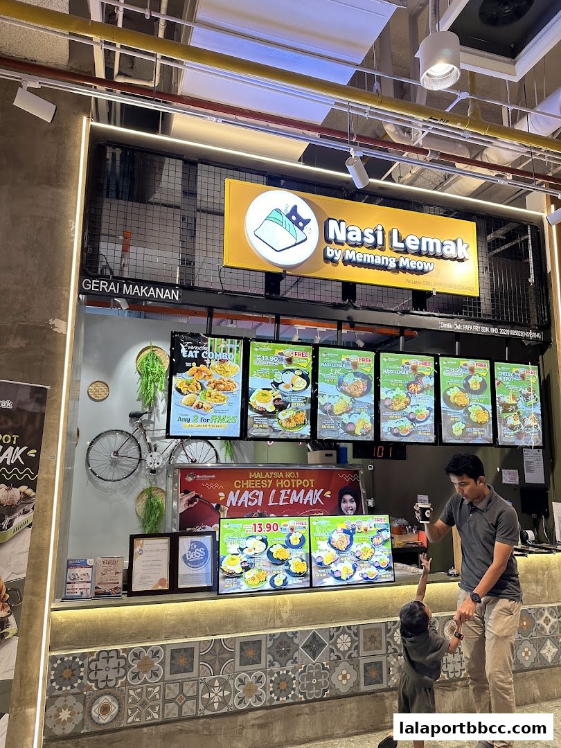 A father and child reach for food at a Nasi Lemak stall with illuminated menus.