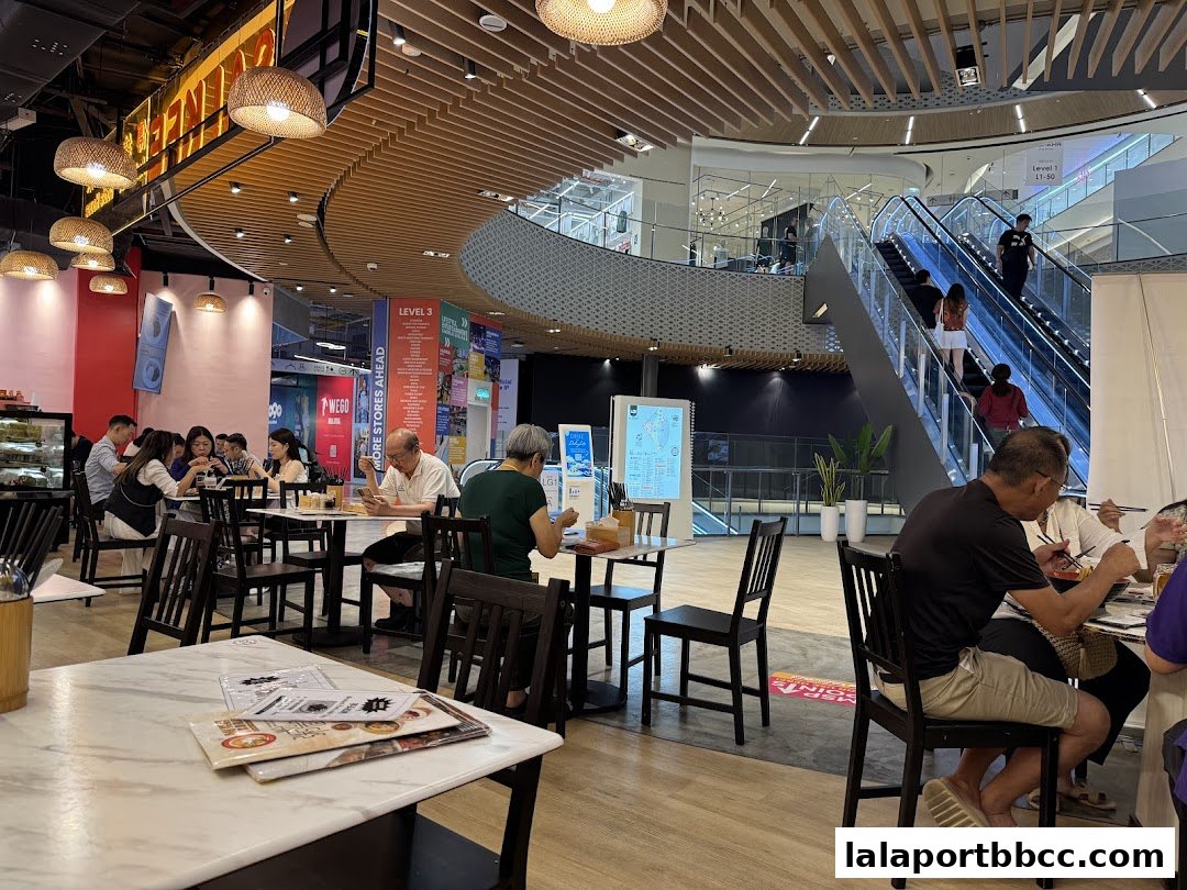 Diners enjoy meals at Sai Kee Restaurant within a modern shopping mall with escalators.