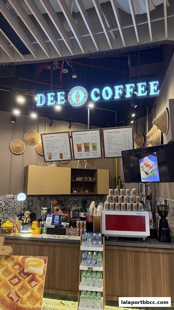 The Dee Coffee shop front with illuminated signage and a menu displayed.