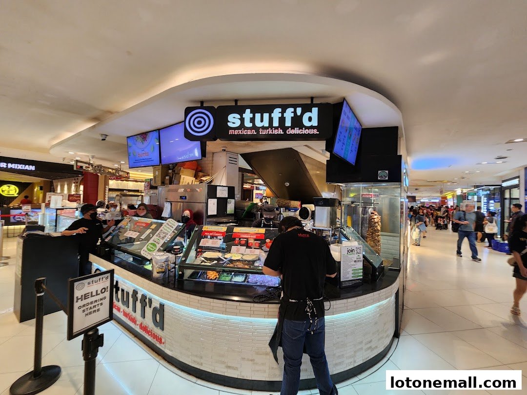 A food stall named Stuff'd with staff serving customers and a vertical rotisserie.