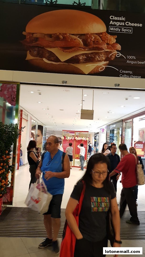 A large advertisement for a Classic Angus Cheese burger is displayed above a busy shopping mall walkway.