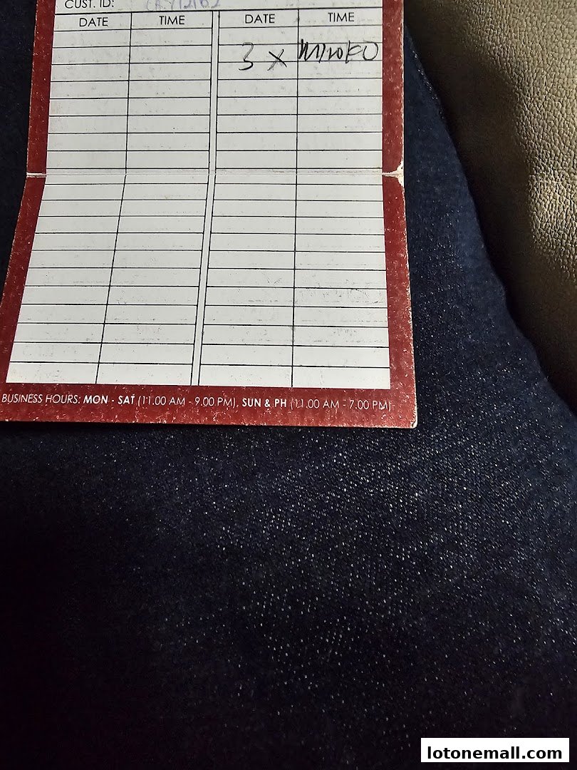 A close-up of a red and white card with fields for customer ID, date, and time, with handwritten notes.