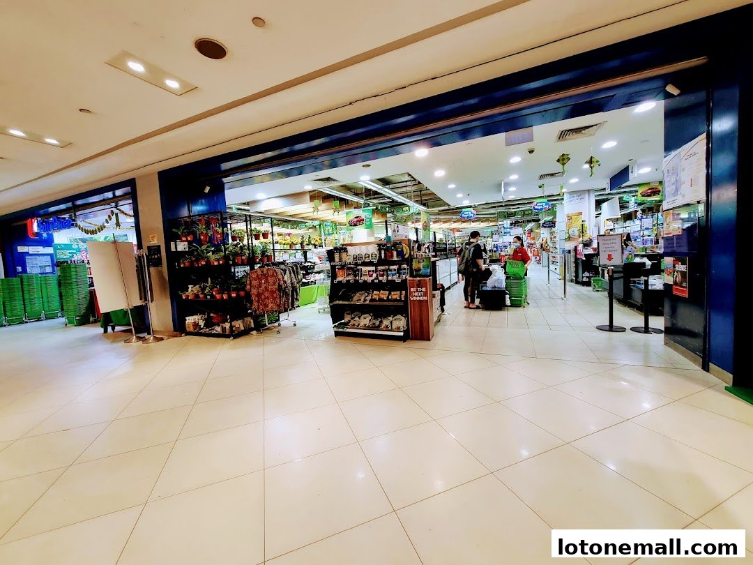 Interior view of a FairPrice supermarket with shoppers and displays of goods.