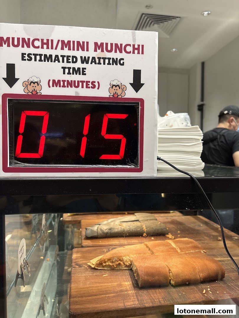 A digital display shows an estimated waiting time of 15 minutes at Munchi Pancakes.