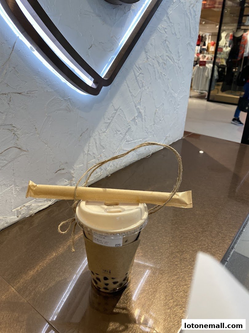 A bubble tea drink from CHICHA San Chen with a straw tied around it.
