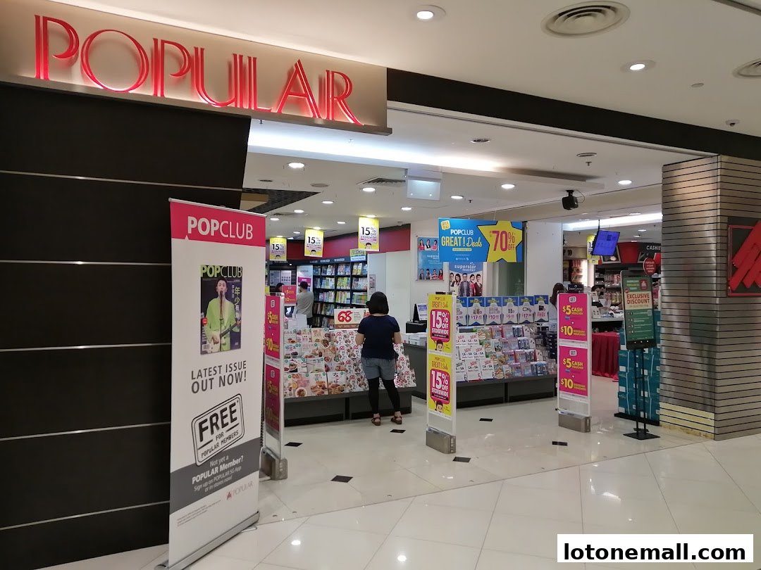 The entrance of POPULAR Bookstore, showcasing promotional banners and displays of books and magazines.