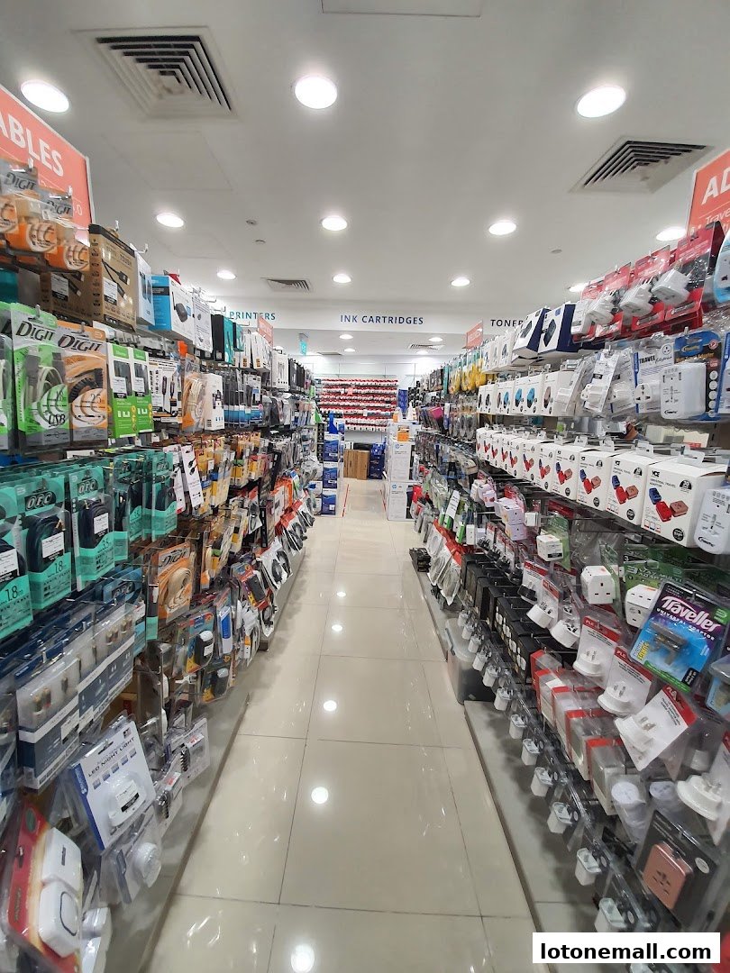Aisle view of a retail store selling electronics accessories like cables, ink cartridges, and adapters.