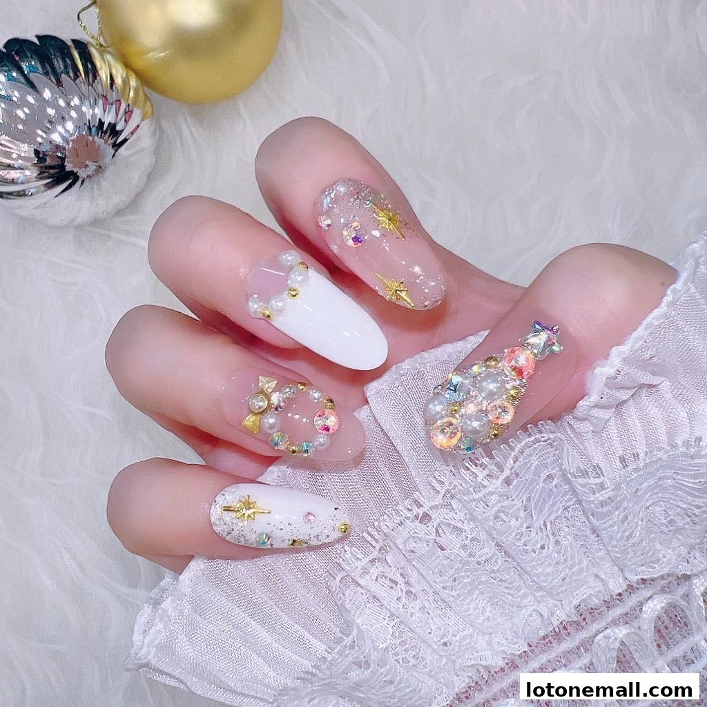 A hand with elaborately decorated nails featuring pearls, gems, and gold accents.