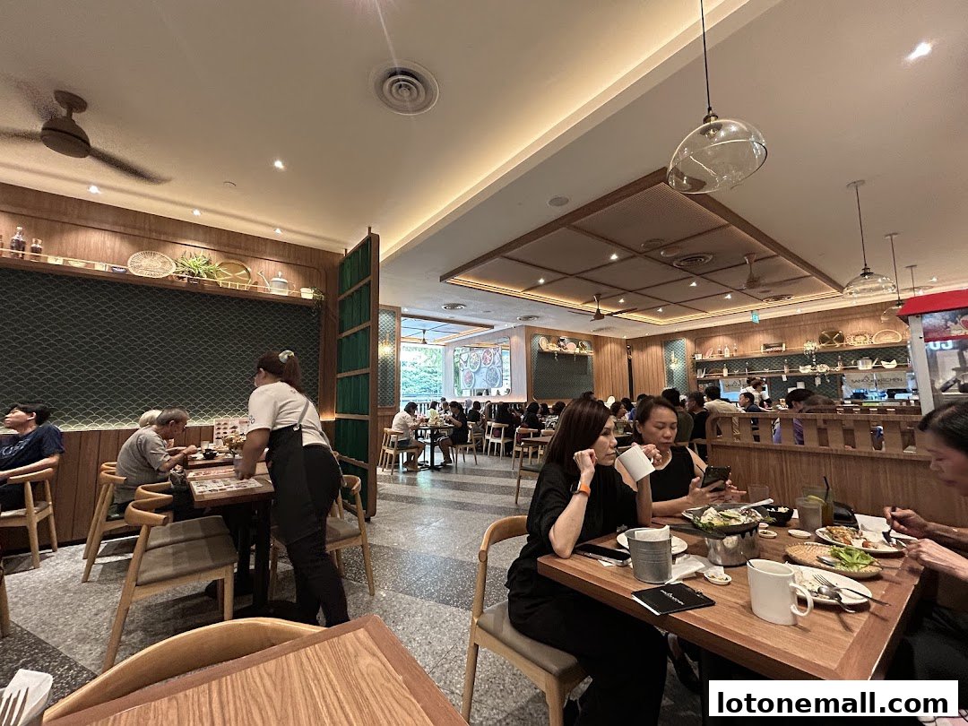 Diners enjoying meals at tables inside a brightly lit restaurant with wooden accents.