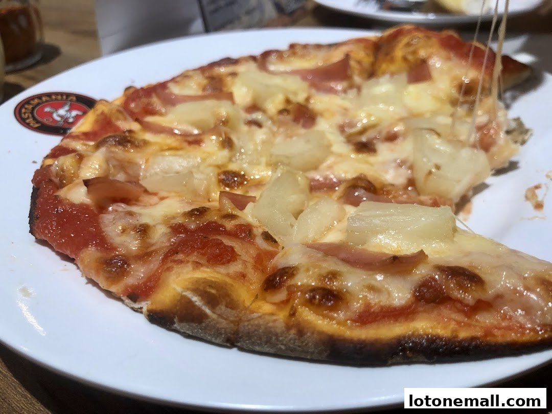 A close-up shot of a delicious Hawaiian pizza with melted cheese and pineapple.