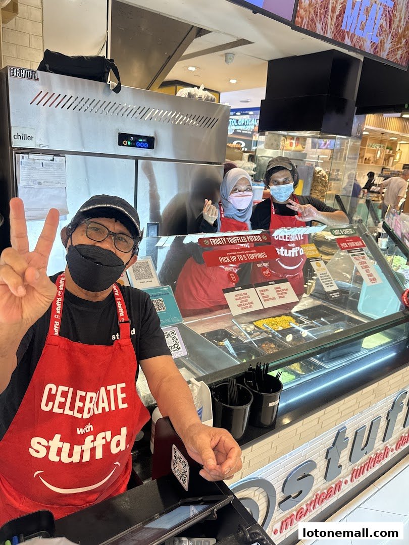 Staff members at Stuffd, a food stall, pose for a photo behind the counter.