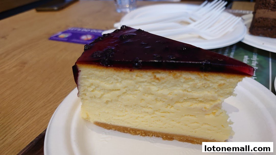 A slice of creamy cheesecake with a blueberry topping on a white plate.