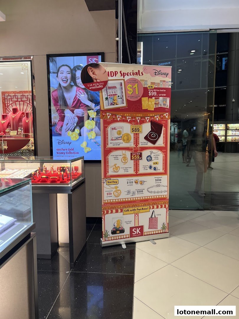 A display banner for SK Jewellery featuring Disney-themed gold items and special offers.