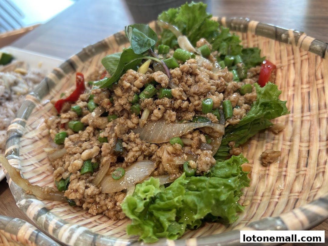 A close-up shot of a delicious Thai minced meat dish served in a woven basket.