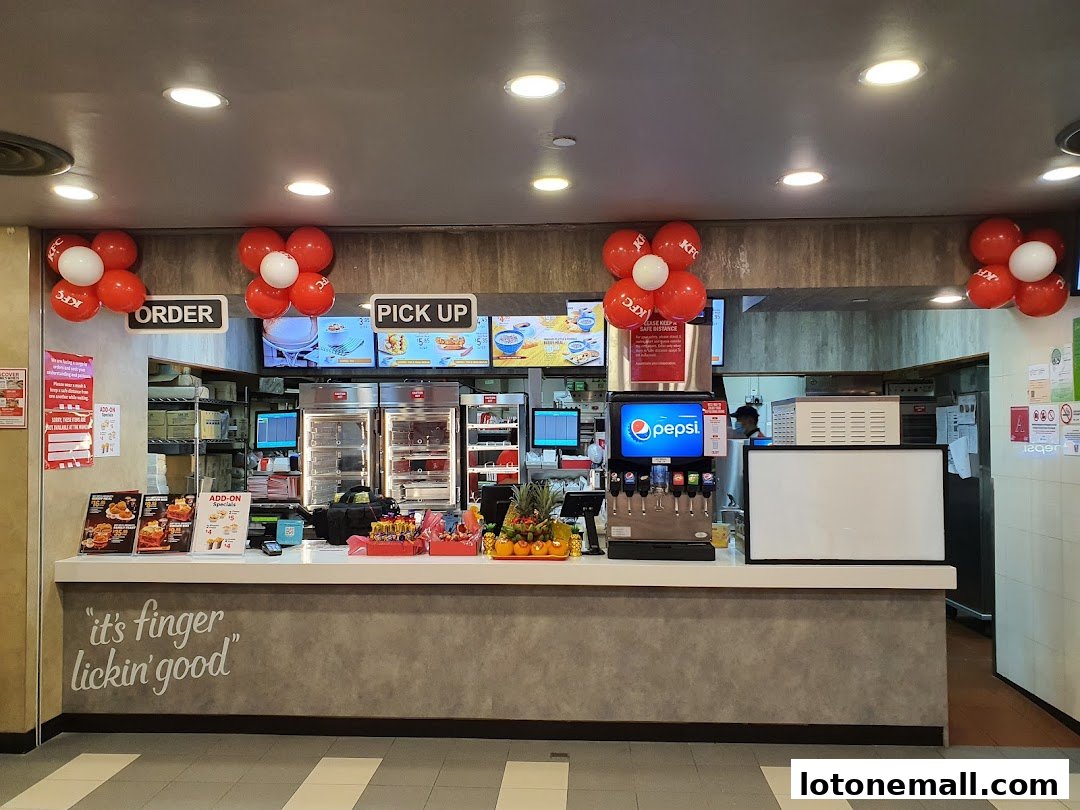 KFC counter with order and pick-up signs, Pepsi dispenser, and festive balloons.