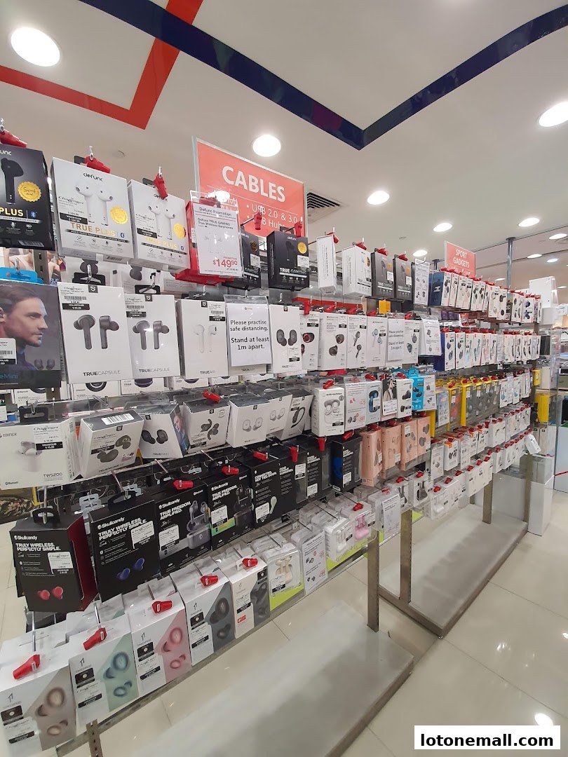 A wide selection of wireless earbuds and audio accessories displayed on shelves in a retail store.