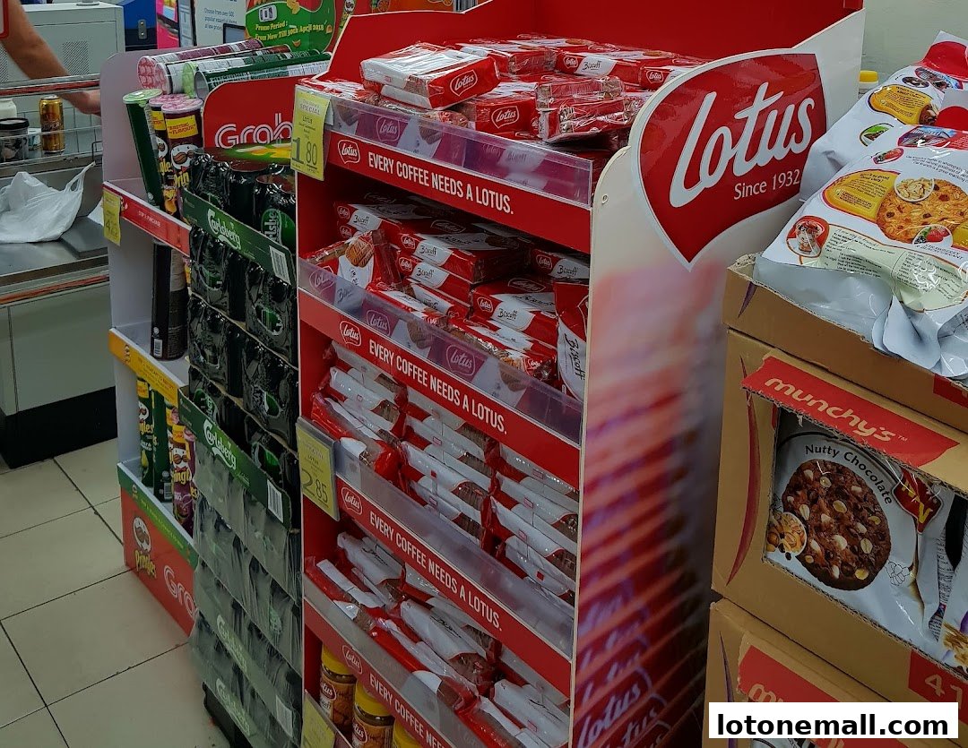 A display of Lotus Biscoff cookies and other snacks in a supermarket aisle.