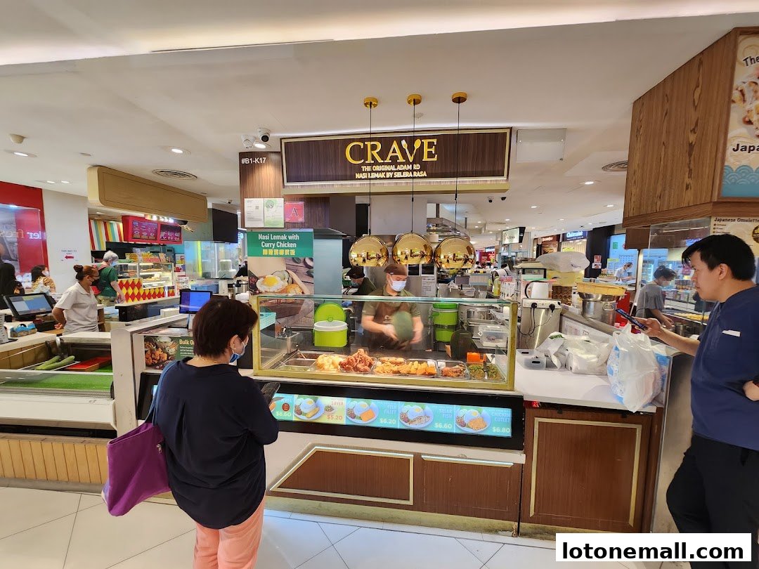 A food stall named Crave Nasi Lemak with customers ordering food.