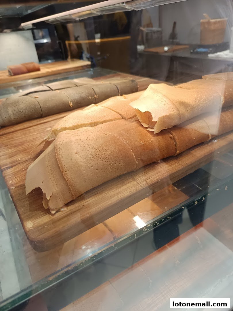 Close-up of freshly made rolled pancakes displayed on wooden boards.