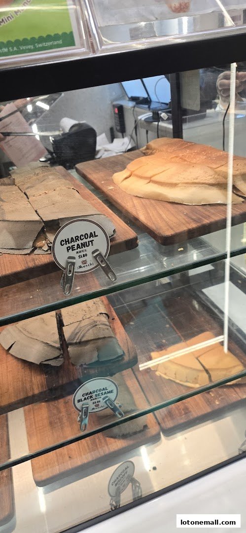 A display case filled with various charcoal-flavored pancakes and sweet treats.