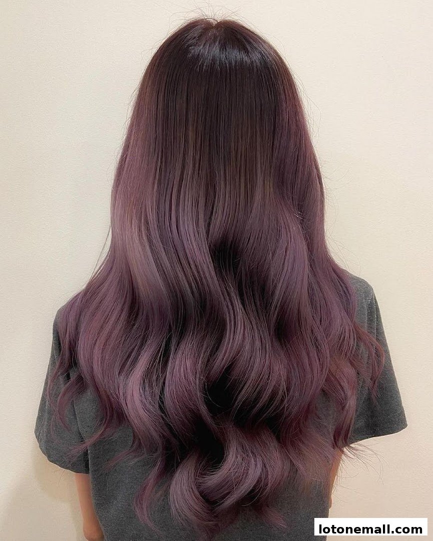 A person's back showcasing long, wavy hair with a beautiful purple ombre.