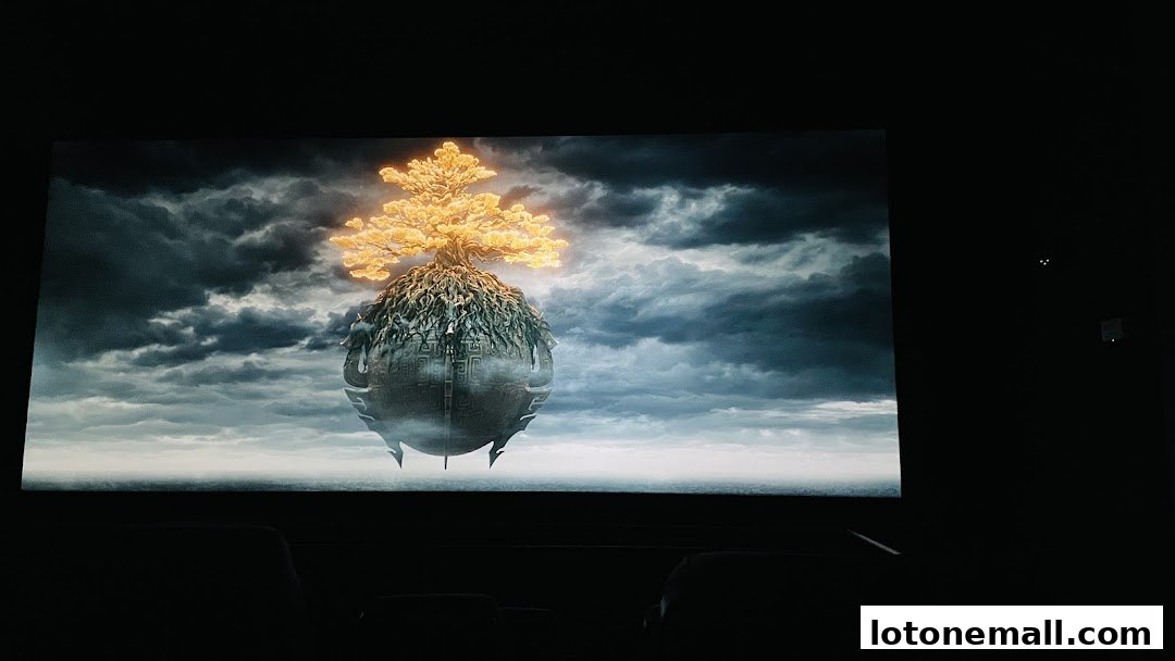 A movie screen displays a fantasy scene with a golden tree on a floating island.