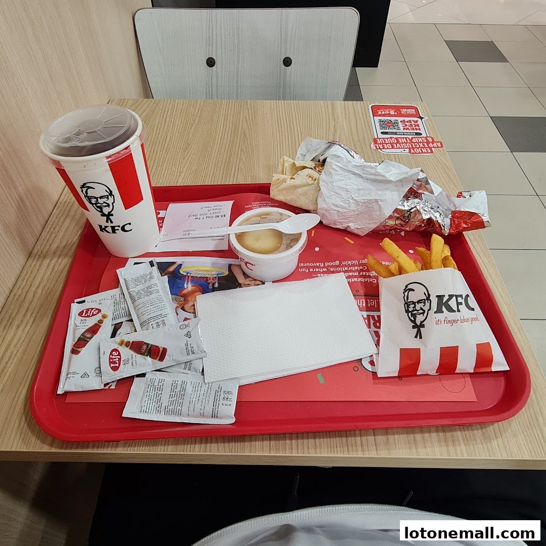 A tray of KFC food including a drink, fries, mashed potatoes, and a wrap.