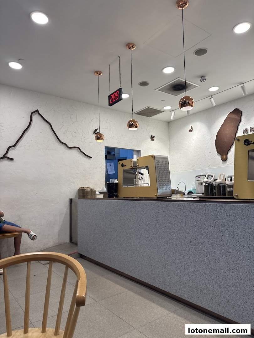 Interior of a modern tea shop with a counter, seating, and decorative elements.