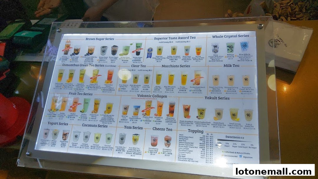 A brightly lit menu board displaying various bubble tea drinks and toppings.