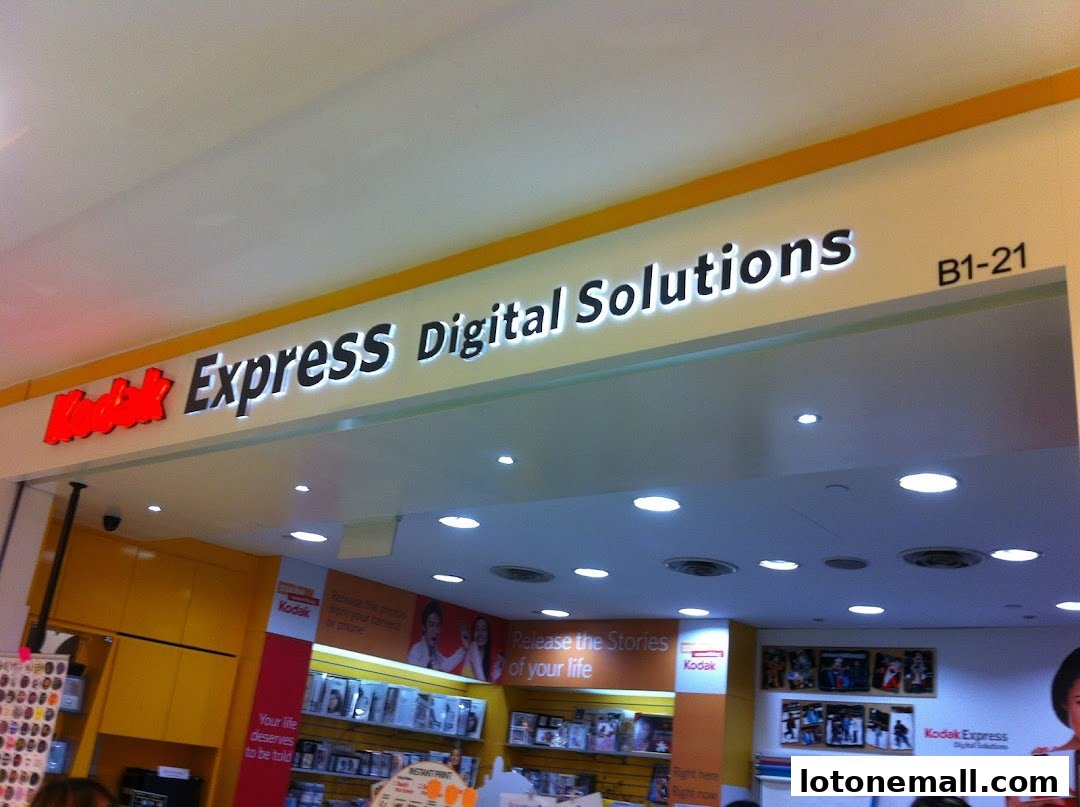 The illuminated sign of Kodak Express Digital Solutions with product displays inside.