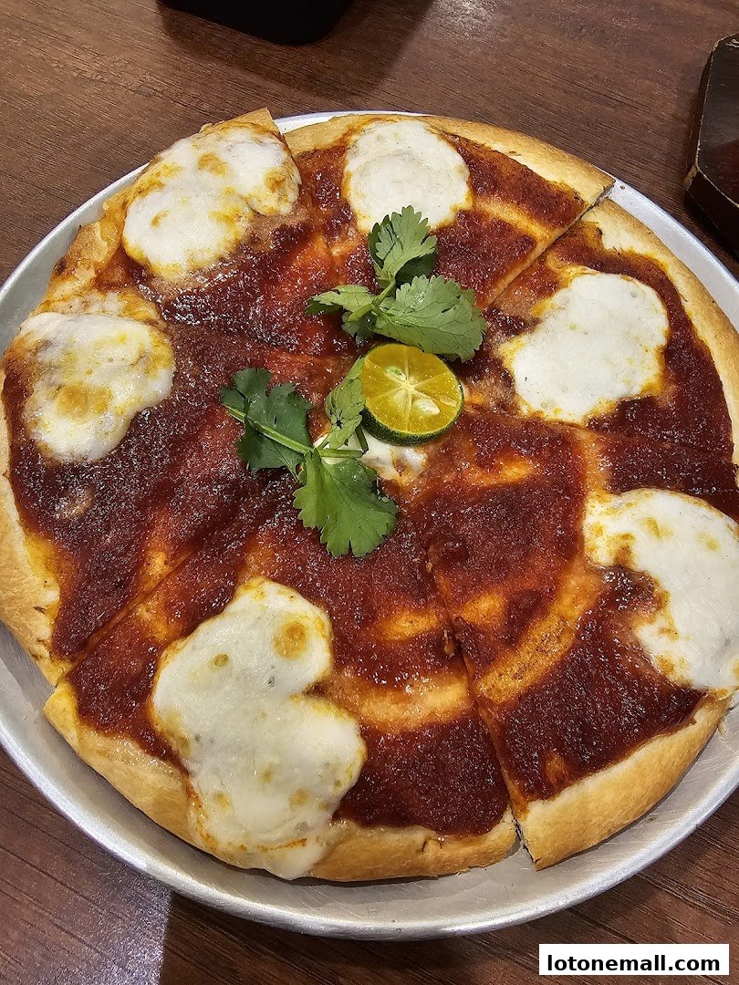 A delicious pizza with red sauce, white cheese, cilantro, and lime.