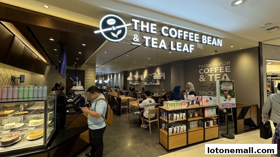 Interior view of The Coffee Bean & Tea Leaf shop with customers and display of cakes and merchandise.