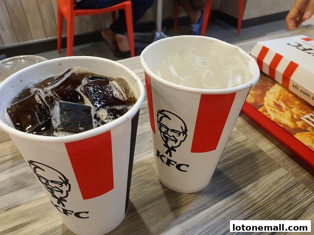 Two KFC cups filled with ice and drinks, with a KFC box in the background.