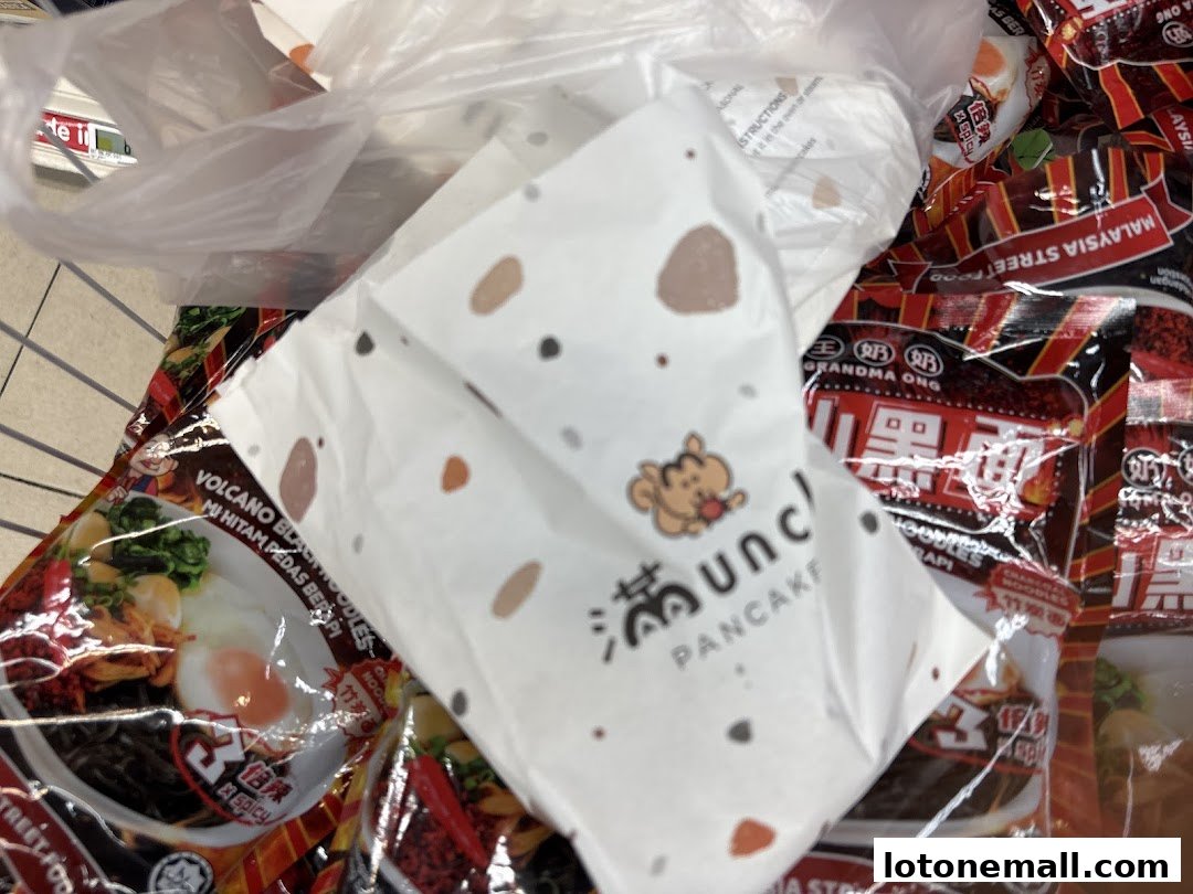 A white paper bag with the Munchi Pancakes logo and polka dots, next to packaged food items.