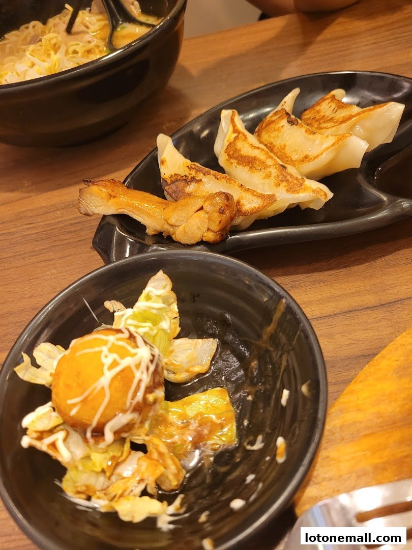 A close-up of delicious Japanese food, including ramen, gyoza, and a unique appetizer.