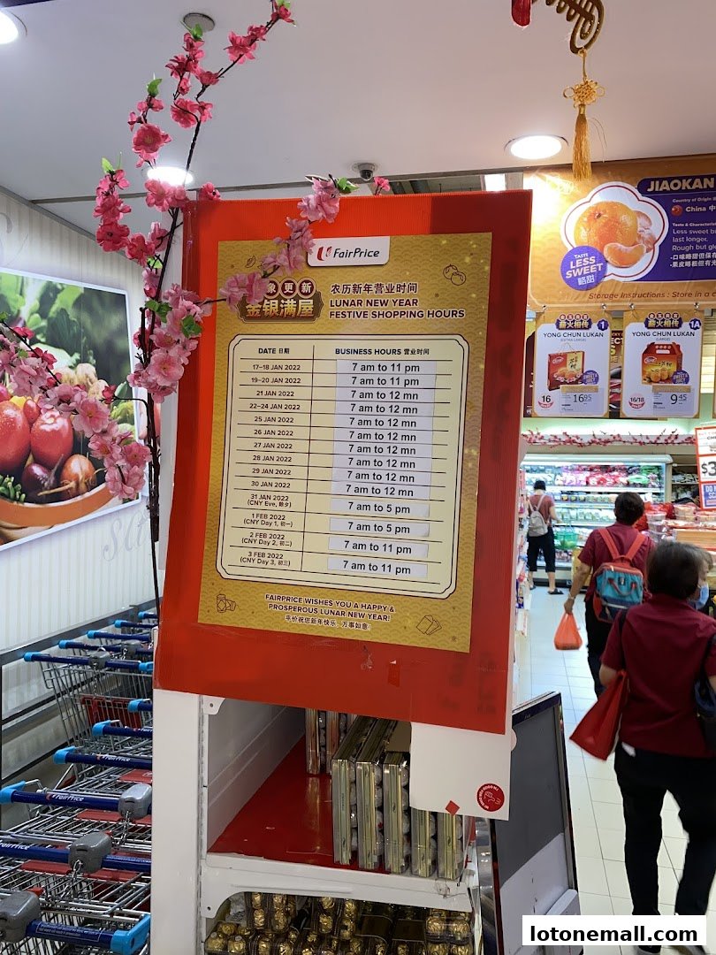 A sign displays Lunar New Year festive shopping hours for FairPrice, with cherry blossoms decorating the display.