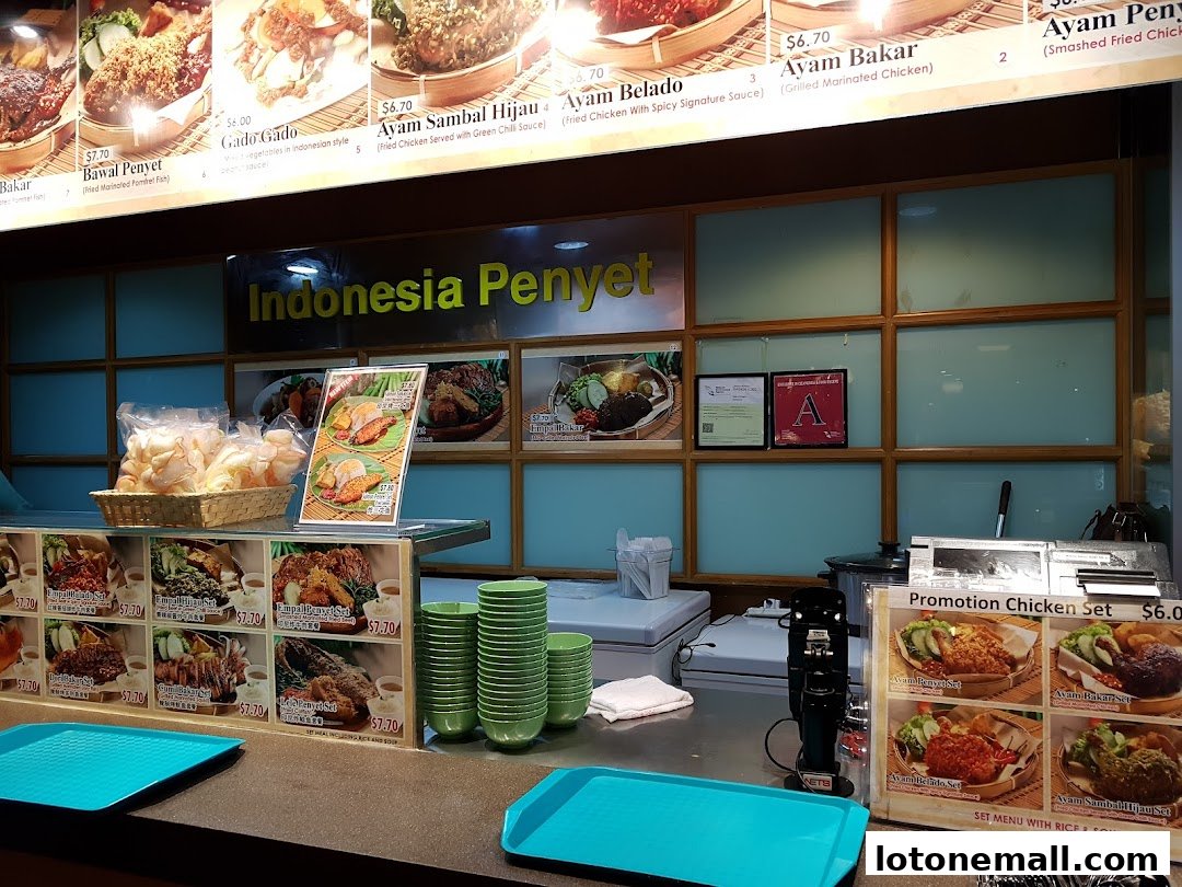 A food court stall displaying Indonesian dishes with prices and enticing food photography.
