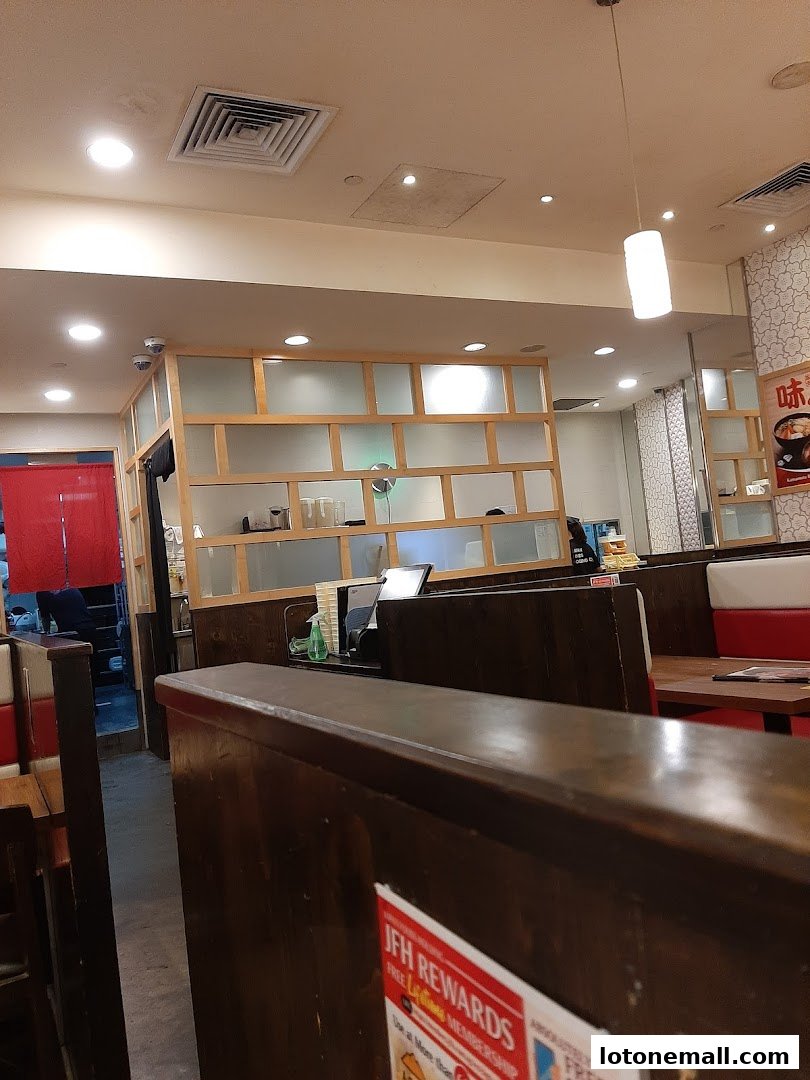 Interior view of Ajisen Ramen restaurant with booth seating and wooden partitions.
