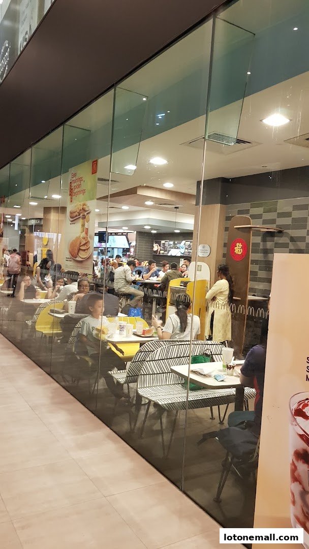 Interior view of a busy McDonald's restaurant with customers dining and staff visible.