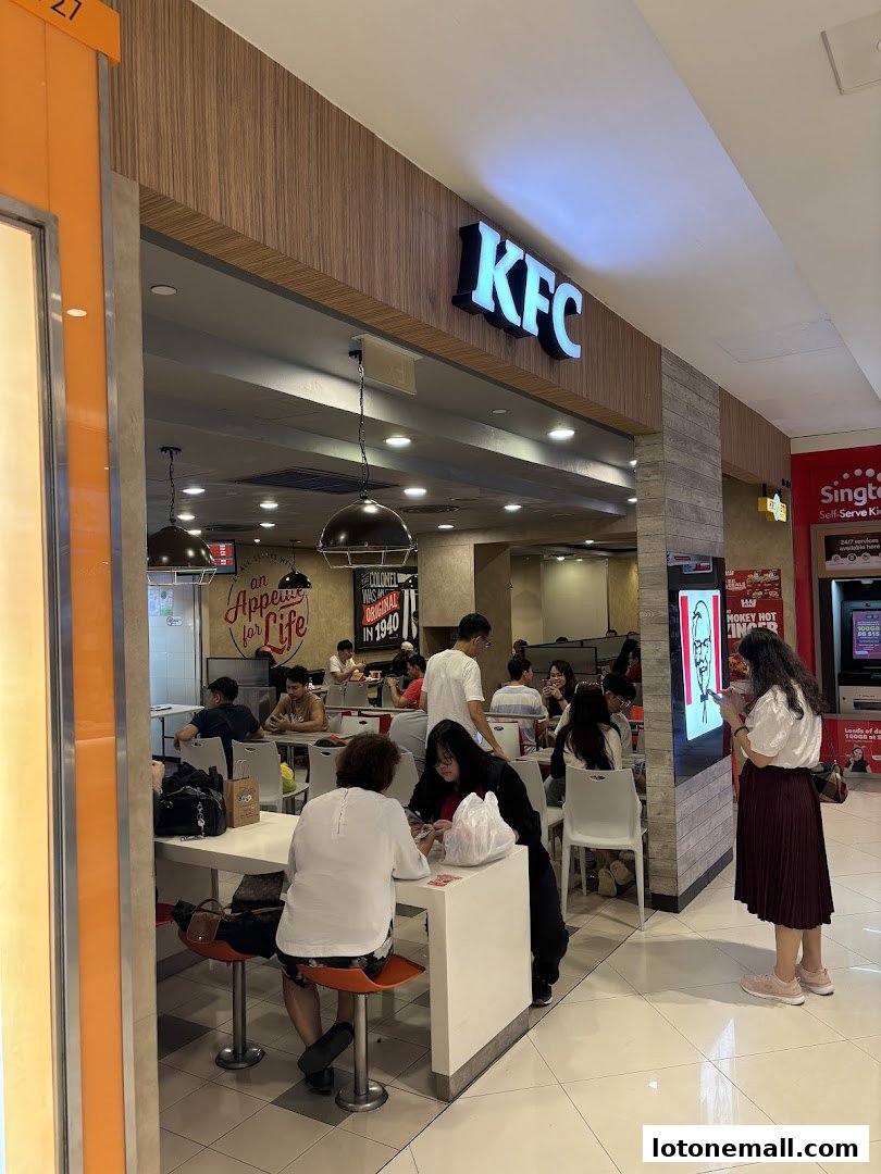 People dining at a KFC restaurant inside a shopping mall.