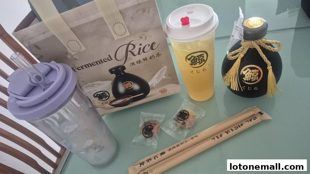 A collection of drinks, snacks, and branded items from The Whale Tea.