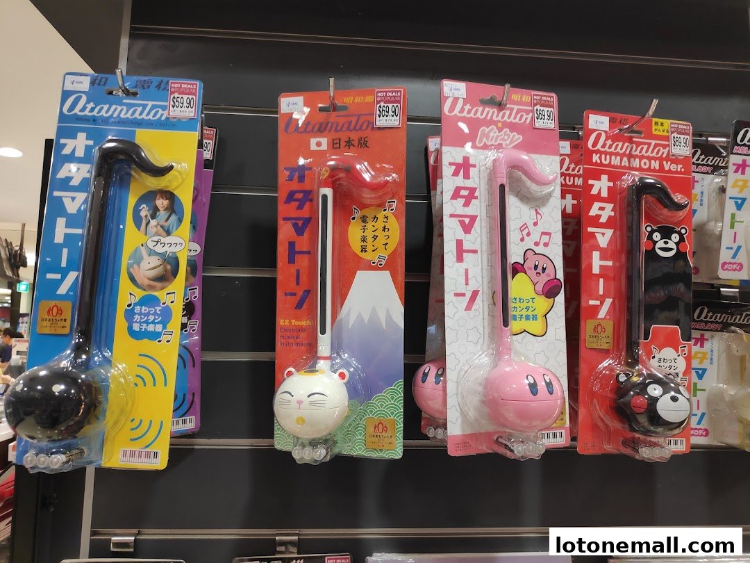 A display of various Otamatone electronic musical instruments in colorful packaging.