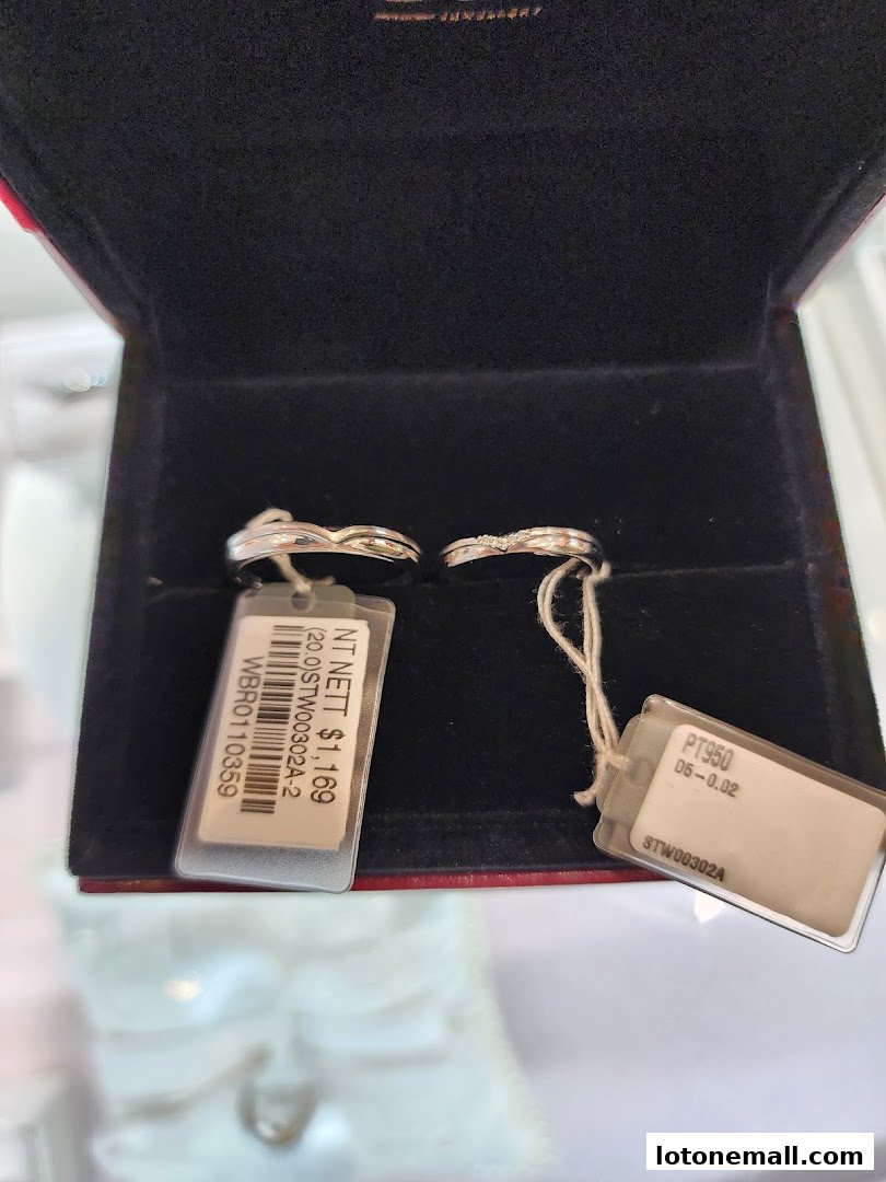 Two elegant diamond rings displayed in a velvet jewelry box with price tags.