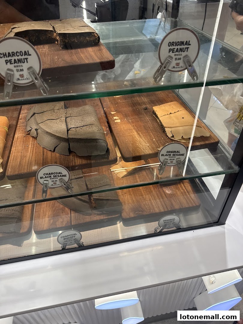 A display case filled with various flavors of pancakes, including charcoal peanut and black sesame.