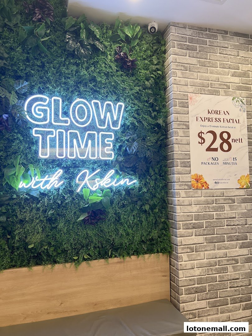 A neon sign reads 'GLOW TIME with Kskin' above a green wall with plants.